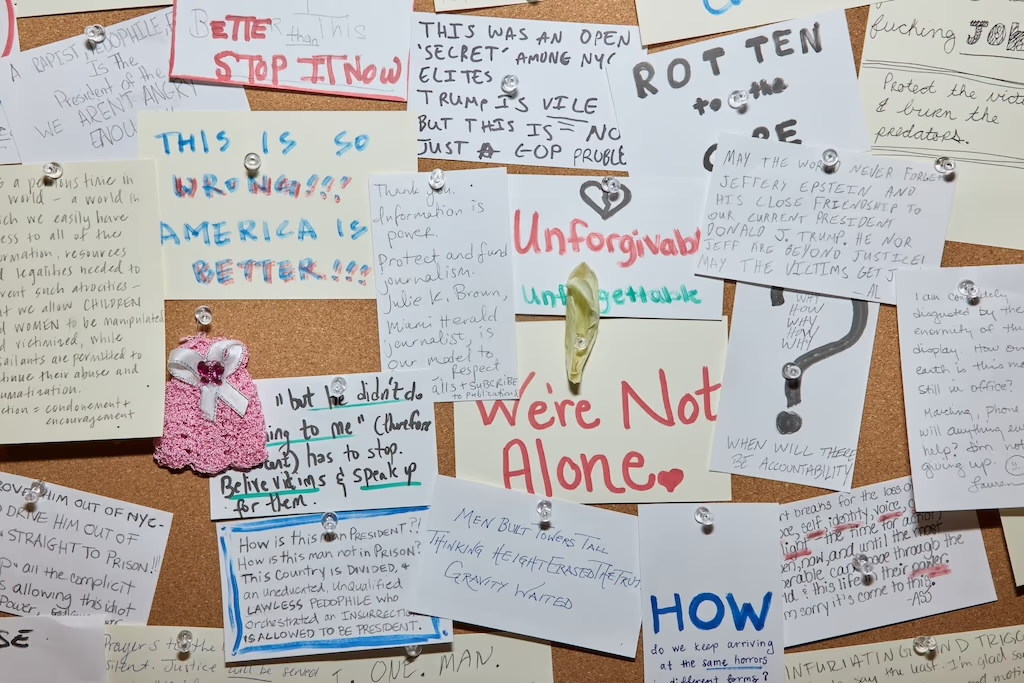 A photo of handwritten notes responding to the crimes of Jeffrey Epstein pinned to a bulletin board. 