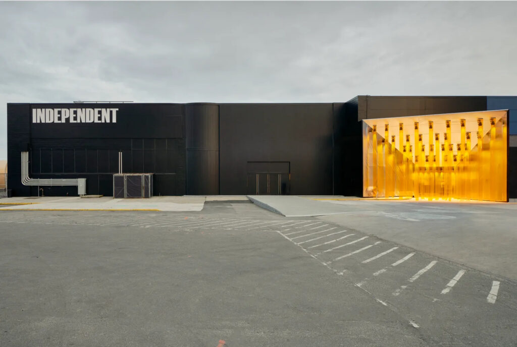 A photo of a black industrial building with a glowing golden entrance and a sign reading "Independent." 