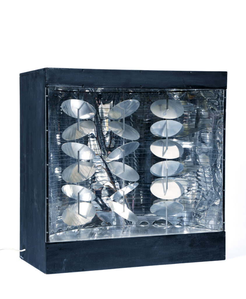 A photo of a light box sculpture with shiny metal discs on columns with a reflective surface behind them, seen against a blank white background.
