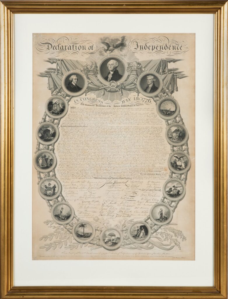 A photo of a framed replica commemorative printing of the Declaration of Independence surrounded by medallion portraits of George Washington, John Hancock, and Thomas Jefferson, as well as the official seals of the thirteen original states.